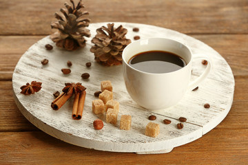 Cup of coffee with sugar and cinnamon on white wooden mat