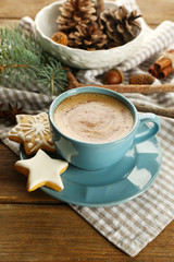 Cup of coffee with star shaped biscuits and Christmas tree branch on napkin