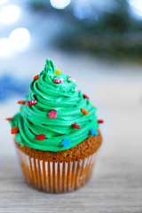 Christmas cupcake with lights on background