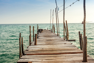 Fototapeta premium Old broken wooden pier on sunset