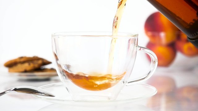 Tea Being Poured into Transparent Cup in Slow Motion.