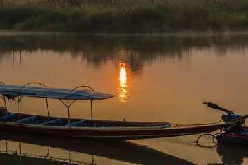 long tail boats on a river on sunrise background