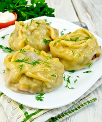 Manty with dill in white dish on board