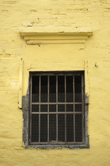 Fototapeta na wymiar The old window on yellow wall
