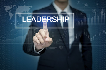 Businessman hand touching LEADERSHIP button on virtual screen