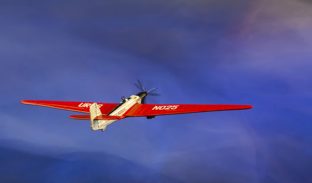 Коллаж с моделью самолёта АНТ-25 на фоне неба
