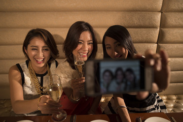 Young women are taken with a smartphone while drinking champagne