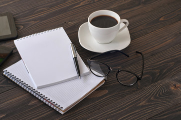 The workplace with notepad, pen and coffee glasses