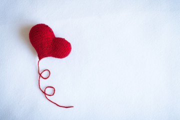 Fototapeta premium red knitted heart knitted white background knitting,