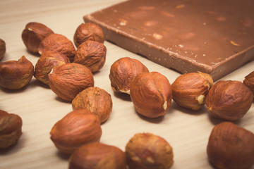 Vintage photo, Nutritious chocolate and hazelnuts on wooden table
