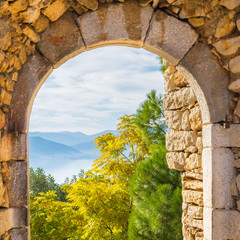Beautiful landscape of trees, mountains and the sea through the old rocks of Palamidi castle at Nafplio city in Greece.
