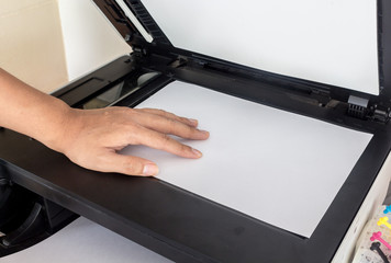 Hand holding paper sheets into printer tray