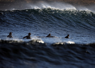 blick über Surfer in Richtung brechender welle