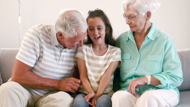 Grandparents Tickling Their Granddaughter