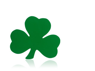 Photograph of a green shamrock shape isolated on white with a reflection below.