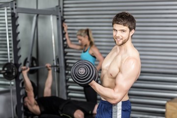 Fototapeta premium Shirtless man lifting dumbbells