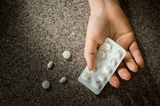Hand of a person to committed suicide with sleeping tablets