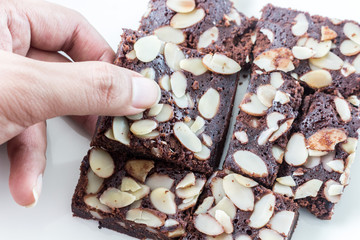 Hand with chocolate brownie  on white