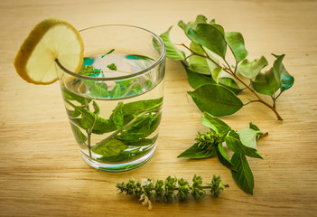 beautiful green tea with mint and lemon on wooden table with whi