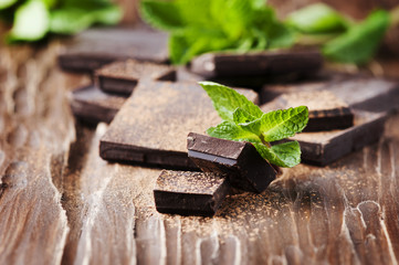 Dark chocolate and green mint on the wooden table