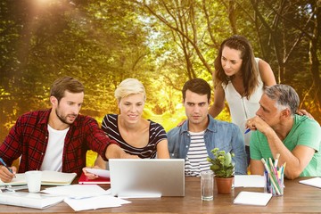 Composite image of teamwork using laptop together