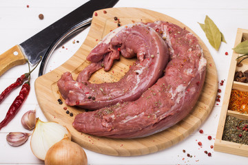 Pork tenderloin on a cutting board with ingredients