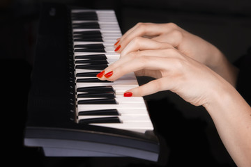 Fototapeta premium Two woman's hands on synthesizer keyboard