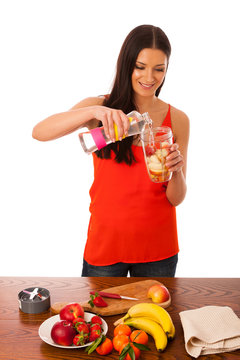 Woman preparing healthy fresh fruit smoothie.