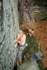 Athletic rock-climber climbing challenging route on cliff rock w