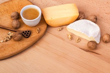 Cheese, walnuts, honey on a wooden table