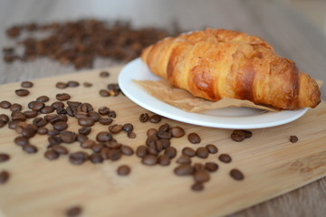 croissant and coffee beans on table