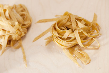 Closeup of homemade raw noodles from spelt dough on wooden table