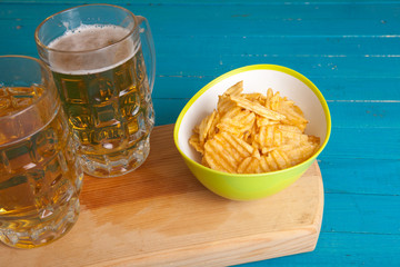 potato chips and two mugs of beer on the table