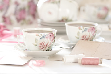 Three cups of tea on a white background. Tea in a bright cups with roses. Vintage style. Bright hues.