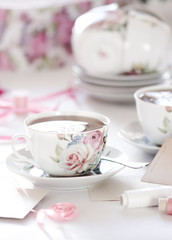 Three cups of tea on a white background. Tea in a bright cups with roses. Vintage style. Bright hues.