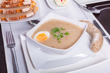 Easter traditional breakfast with white borsch soup, eggs and sausages