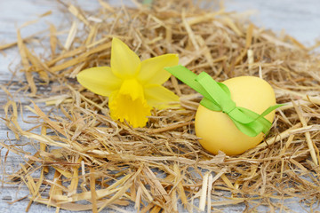 Osterei mit Blume im Stroh