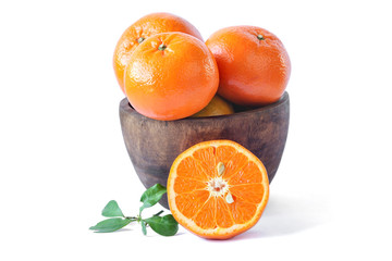 Half of orange fruit with leaf and orange on wooden bowl on white background, citrus fruit.
