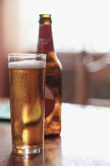 glass of beer with bottle on the table