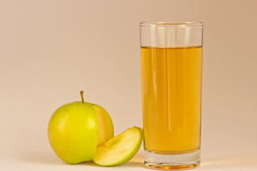 Яблочный сок.\Высокий стакан с яблочным соком и оригинально расположено яблоко.