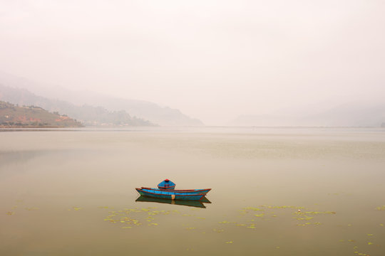 Couple of boat on Mountain Lake in Morning fog landscape. Loneliness, silence outdoor