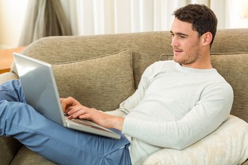 Man using laptop on sofa
