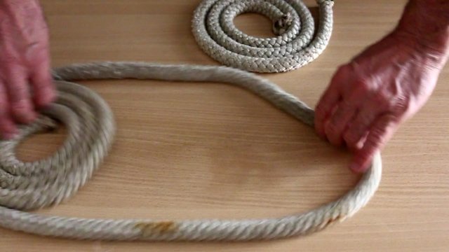 Esecuzione di nodi marinari con corda di canapa su piano in legno