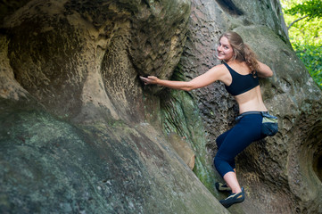 young woman climbing on large boulders