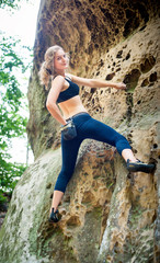 young woman climbing on large boulders