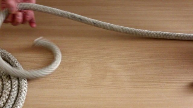 Esecuzione di nodi marinari con corda di canapa su piano in legno