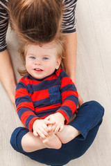Fototapeta premium Mom plays with the baby lying on the floor