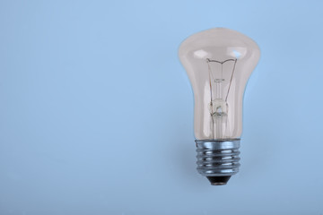 traditional incandescent light bulb on blue background