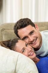 Portrait of young couple cuddling on sofa