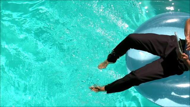 Businessman using his tablet sitting on buoy